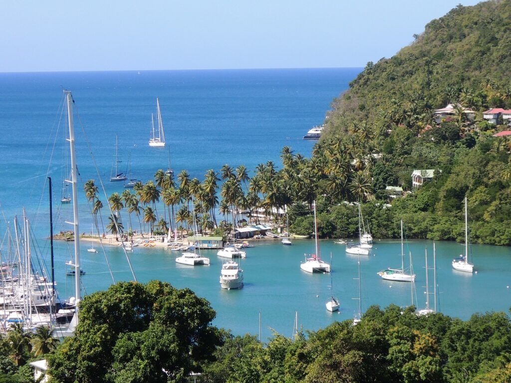 The iconic Pitons of St. Lucia, towering volcanic spires surrounded by lush rainforest and clear waters.