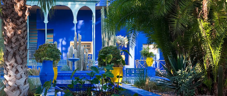 Enchanting scene at Jardin Majorelle in Marrakech, a must-visit attraction showcasing stunning blue architecture amid lush greenery, perfect for travelers exploring the city's cultural and natural beauty."