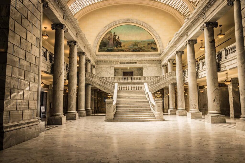 Grand marble interior of the Utah State Capitol building, featuring an elegant staircase and towering columns under a domed ceiling, capturing the architectural beauty of one of the must-see attractions in Salt Lake City in 2025