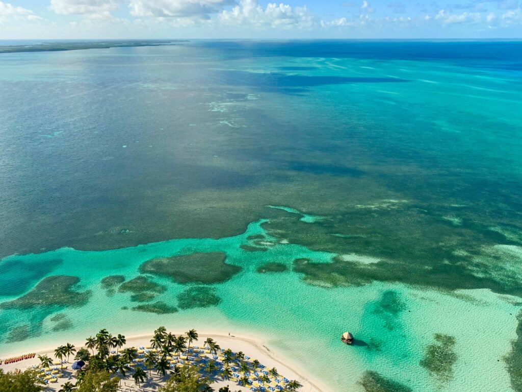 Stunning aerial view of the Bahamas with clear blue waters, coral reefs, and white sandy beach.