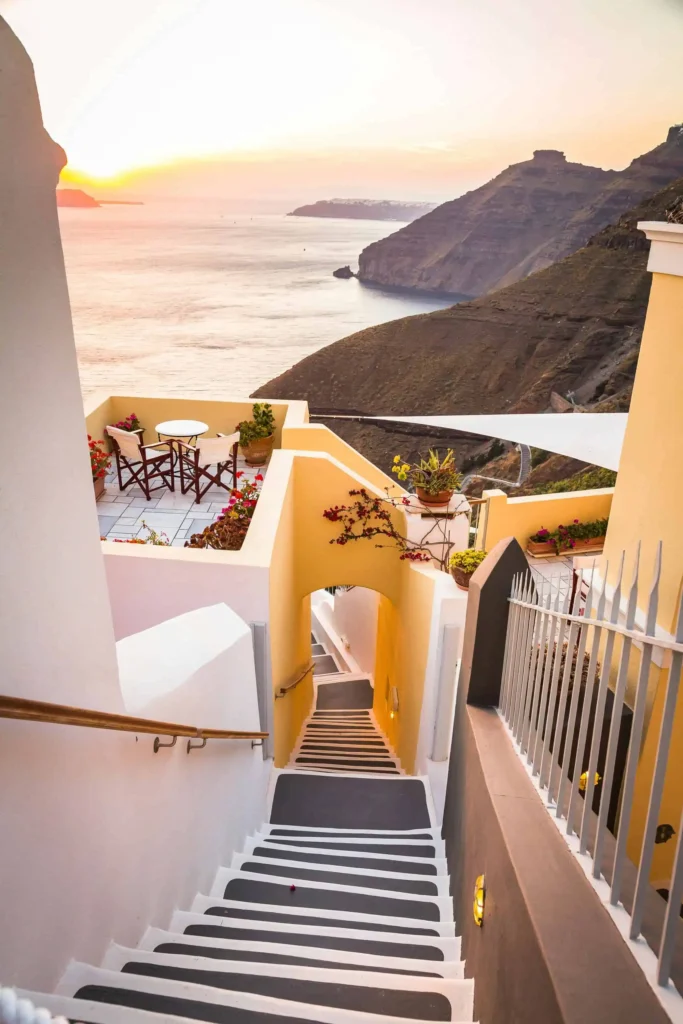 Honeymoon destinations all inclusive Greece: Iconic white church bell tower overlooking the Aegean Sea during a serene sunset in Santorini, Greece, showcasing traditional Cycladic architecture and romantic scenery