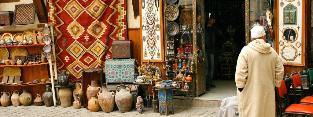 A vibrant Moroccan souk filled with traditional ceramics, colorful rugs, and handcrafted artifacts in Marrakech, Morocco