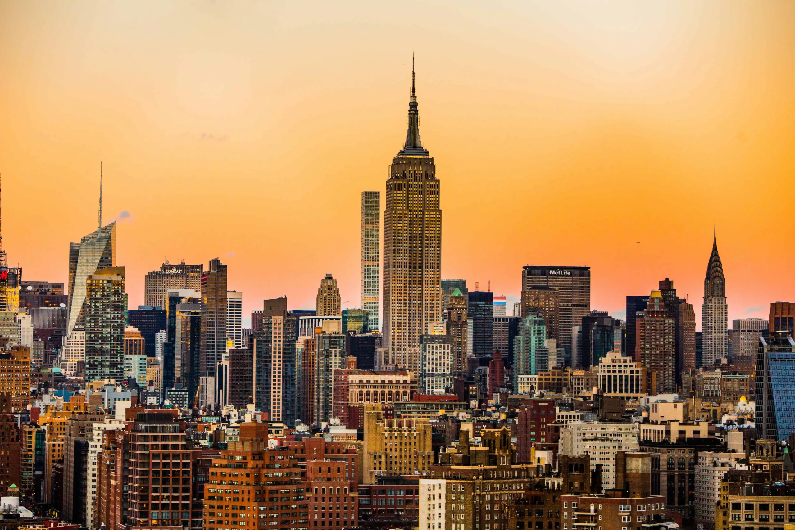 Best places to travel in the US in January: Stunning view of New York City’s skyline at sunset, featuring the Empire State Building and vibrant orange hues in the sky