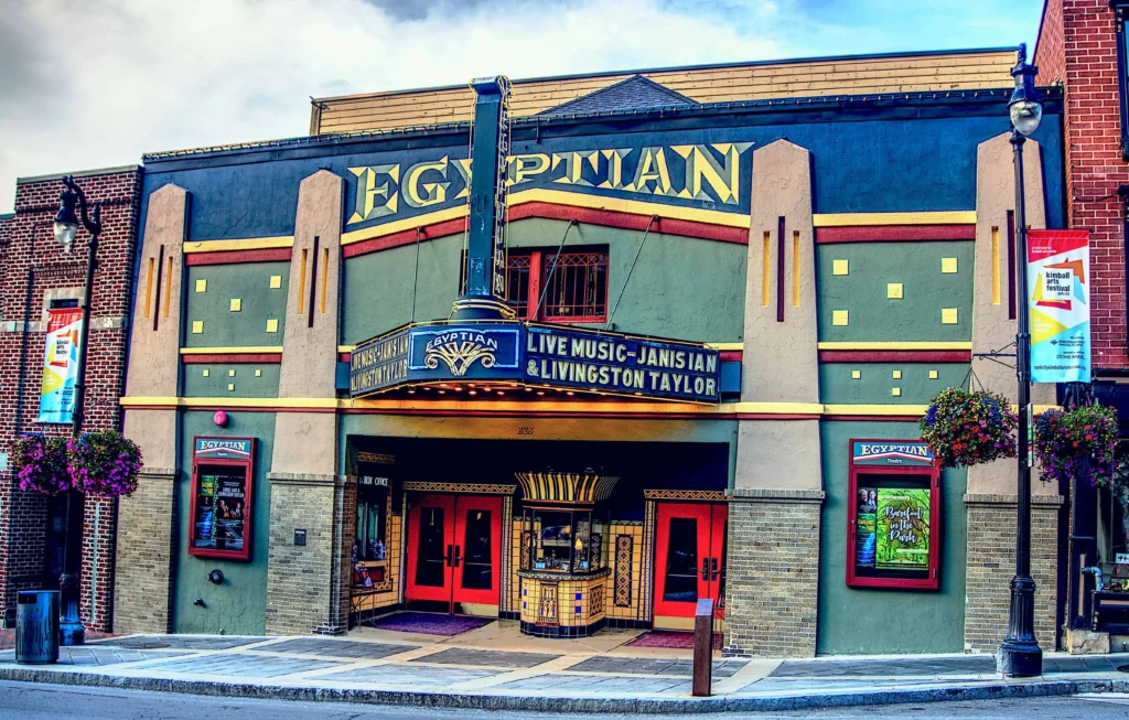 Best places to travel in the US in January: A vibrant exterior of the historic Egyptian Theatre in Park City, Utah, showcasing its colorful facade and marquee promoting live music events, against a bright winter sky