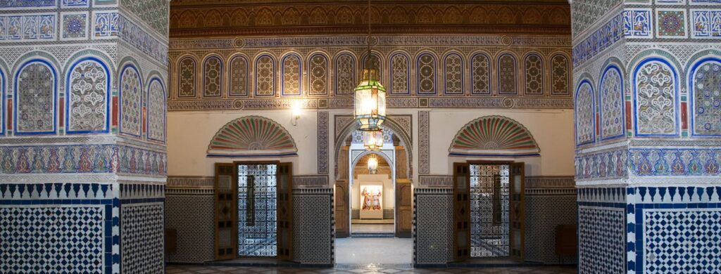 Ornate Moroccan architecture inside the Dar Si Said Museum, featuring colorful mosaics and intricate archways