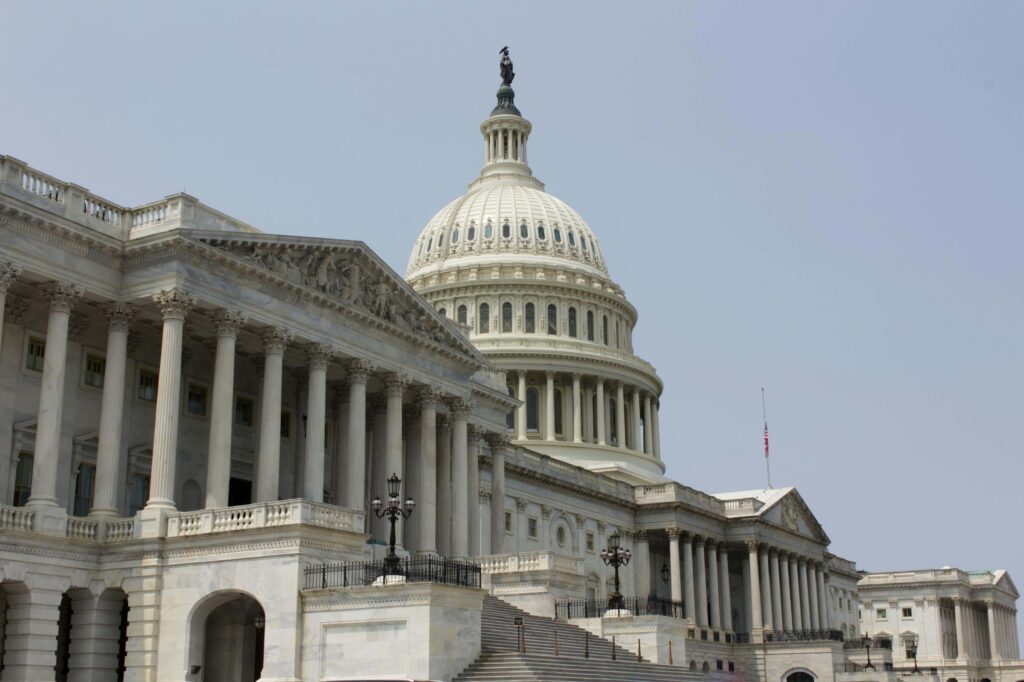 Close-up view of the United States Capitol Building in Washington, D.C., showcasing its majestic dome and neoclassical architecture under a clear sky.