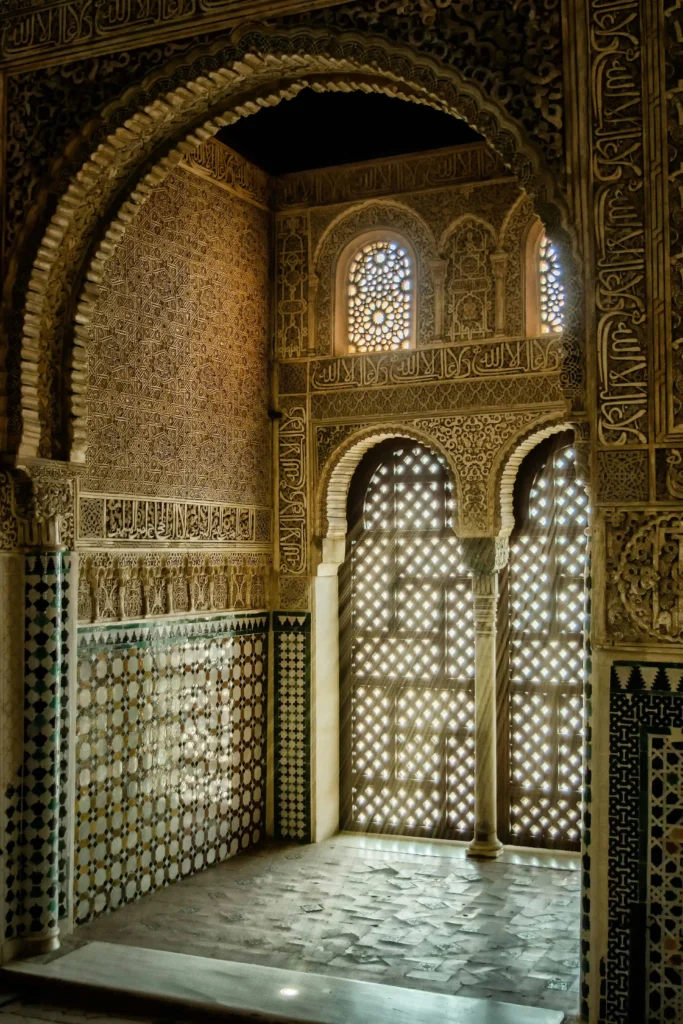 Intricate Islamic geometric patterns and carved wooden windows in a serene room inside The Alhambra in Granada, illuminated by natural light