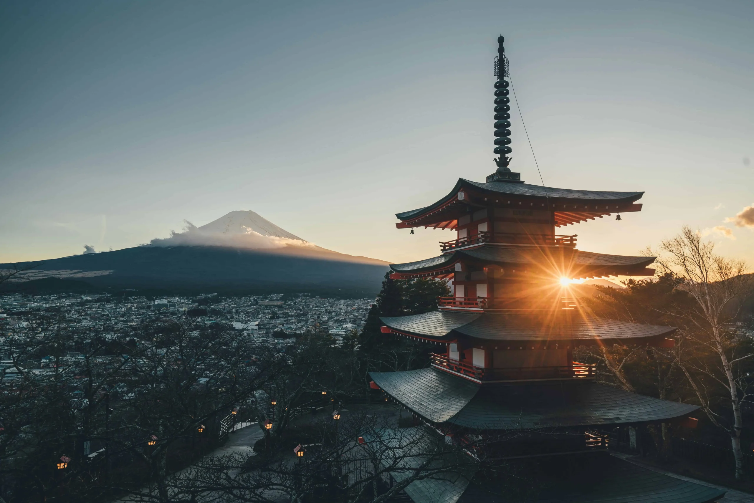 Traditional Japanese pagoda with Mount Fuji in the background during a serene sunrise, symbolizing the harmony of Japan's cultural heritage and natural beauty.