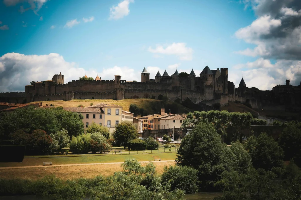 The fortified medieval city of Carcassonne, France, with its iconic castle and lush greenery surrounding it