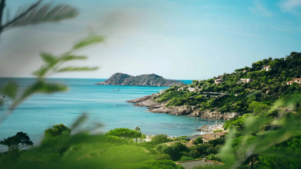 A serene view of the French Riviera with turquoise waters, rocky coastlines, and lush greenery.