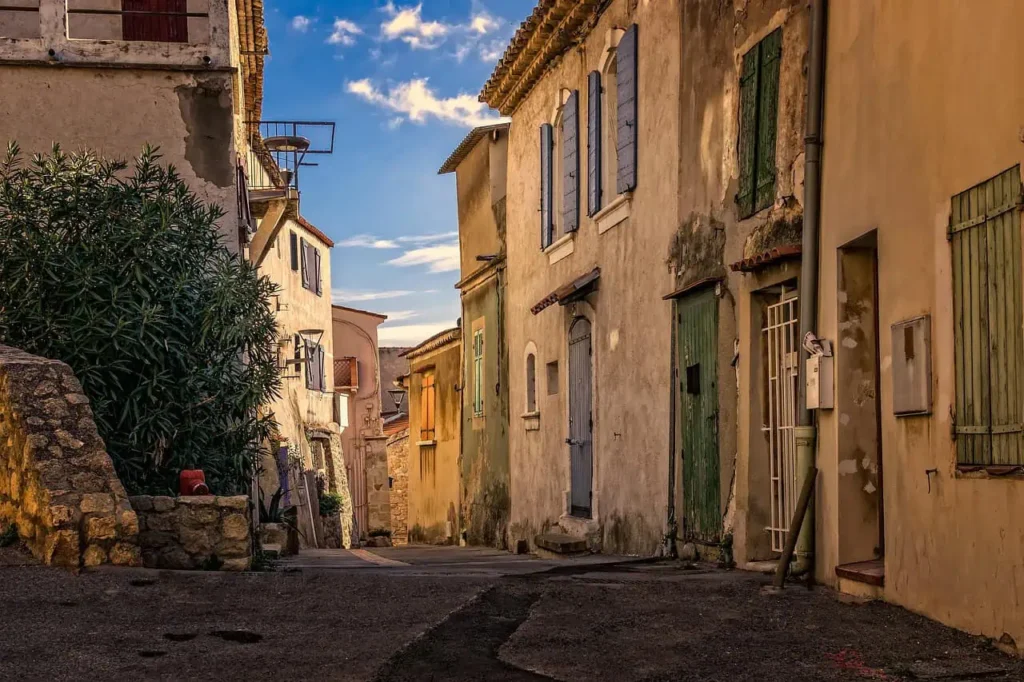 Charming narrow alleyway showcasing south of france vacation France village with rustic stone houses and colorful shutters.