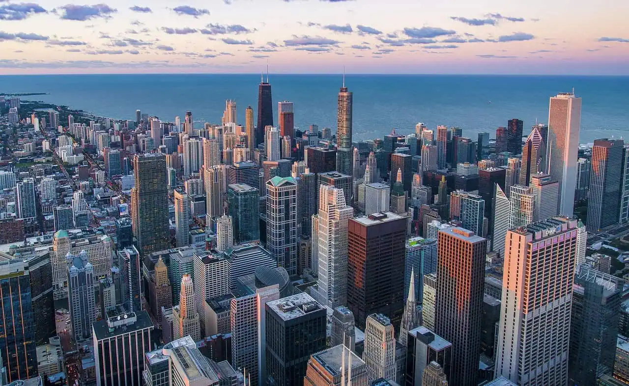 A stunning aerial view of downtown Chicago's skyline with Lake Michigan in the background at sunset.