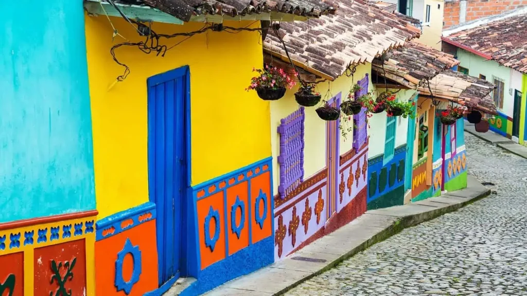 A charming street in Colombia sa with bright yellow and blue colonial-style houses, adorned with hanging flower pots and traditional tiled roofs
