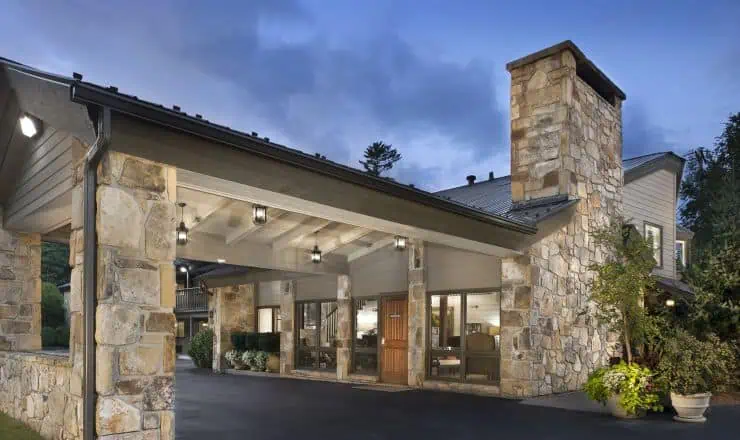 Front view of 200 Main by Old Edwards in Highlands, NC, featuring stone architecture and warm lighting under an evening sky.