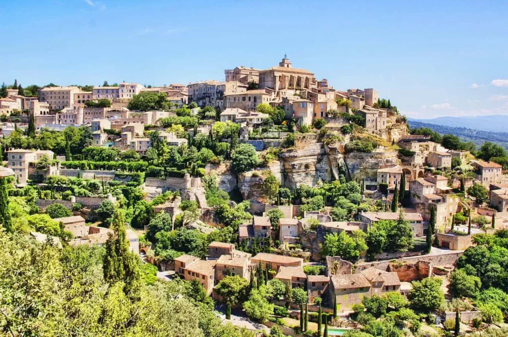 The hilltop village of Gordes in Provence, surrounded by lush greenery and traditional stone houses