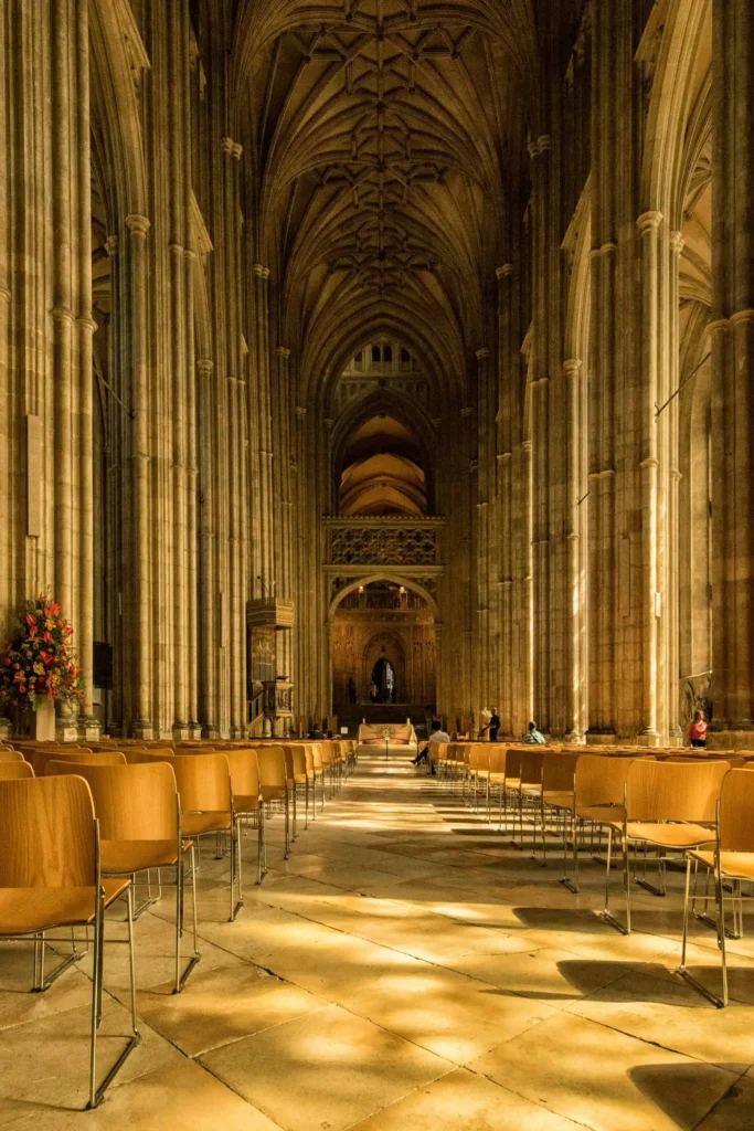 The majestic interior of Canterbury Cathedral with gothic arches and sunlight streaming through the windows