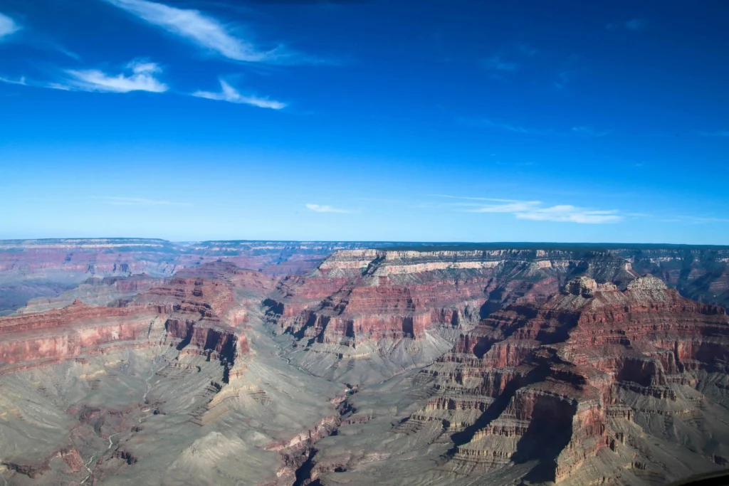 The Grand Canyon under clear blue skies, showcasing its layered rock formations