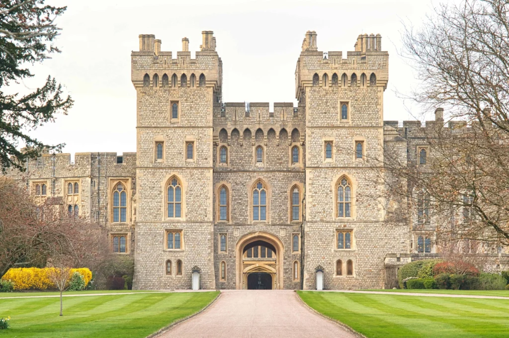 The grand entrance of Windsor Castle with neatly trimmed lawns and historic stone towers