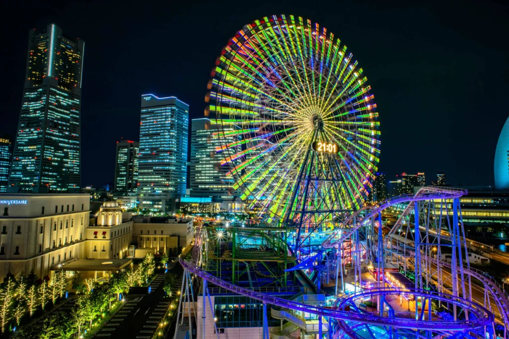 A vibrant night view of Minato Mirai district with the illuminated Cosmo Clock 21 Ferris wheel in Yokohama, Japan.