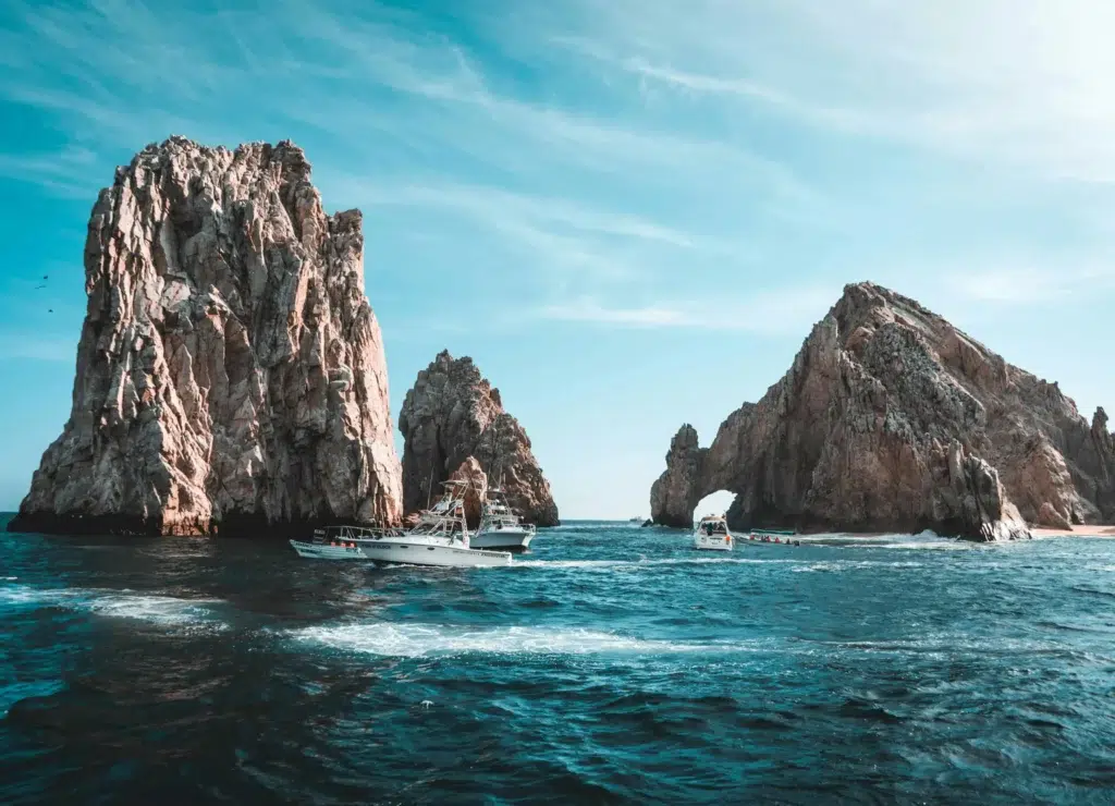 The famous Arch at Land’s End in Cabo San Lucas, surrounded by clear blue skies and calm ocean waters with boats nearby.