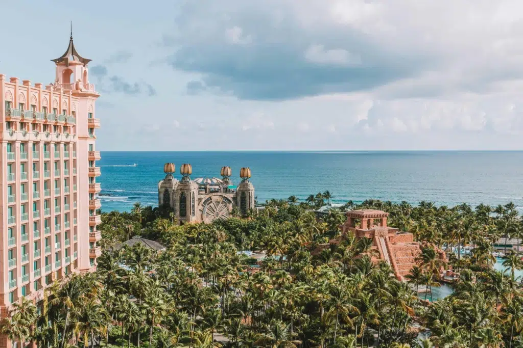 A panoramic view of Atlantis Resort on Paradise Island with lush greenery and the turquoise ocean in the background.