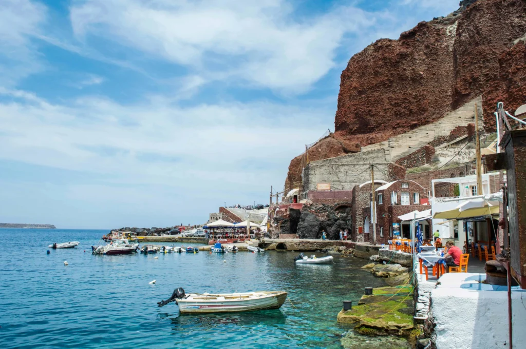 Vibrant tavernas and fishing boats in Ammoudi Bay at the foot of Oia, Santorini, offering a charming seaside experience.