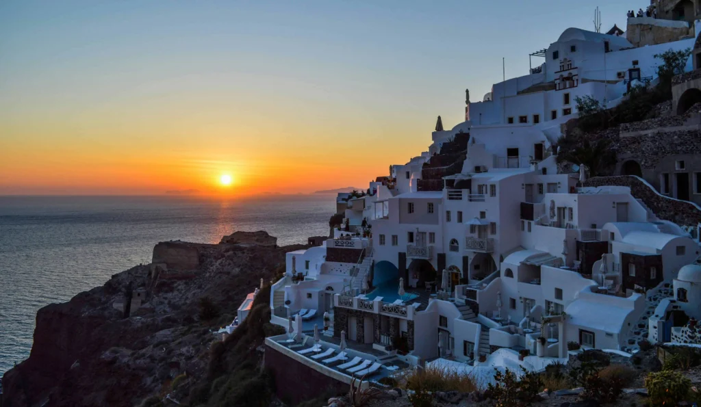 The mesmerizing glow of Santorini's whitewashed buildings at dusk, creating a romantic ambiance perfect for honeymooners. (Keyphrase: Santorini Greece Honeymoon)