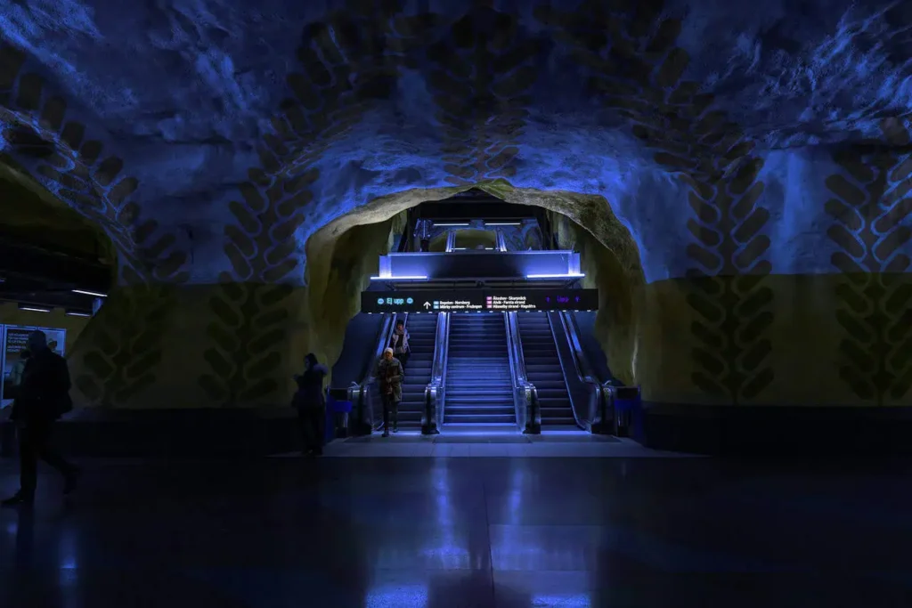 A stunning image of a dimly lit underground station with blue-themed architecture and escalators, resembling the innovative design found in the Washington DC underground museum.