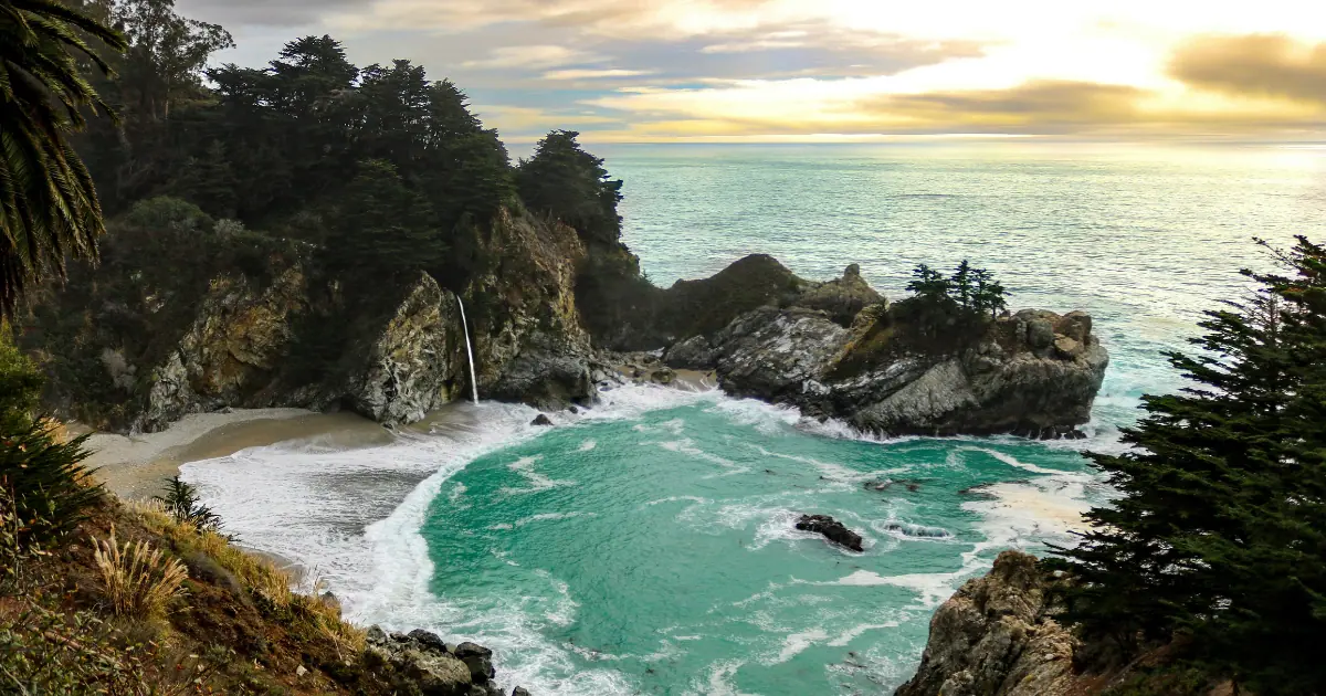 McWay Falls in Big Sur during sunset with turquoise water and rocky cliffs.