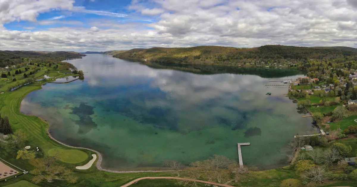 A stunning aerial view of Otsego Lake in Cooperstown, NY, showcasing its clear waters and surrounding greenery.