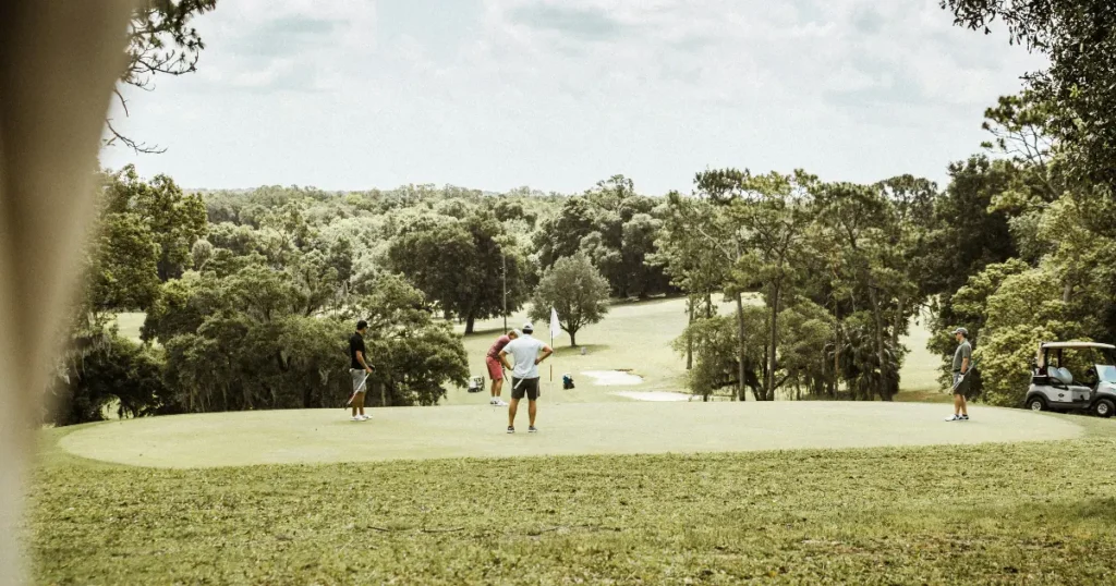 A group of golfers playing on a lush green golf course in Mount Dora, Florida.