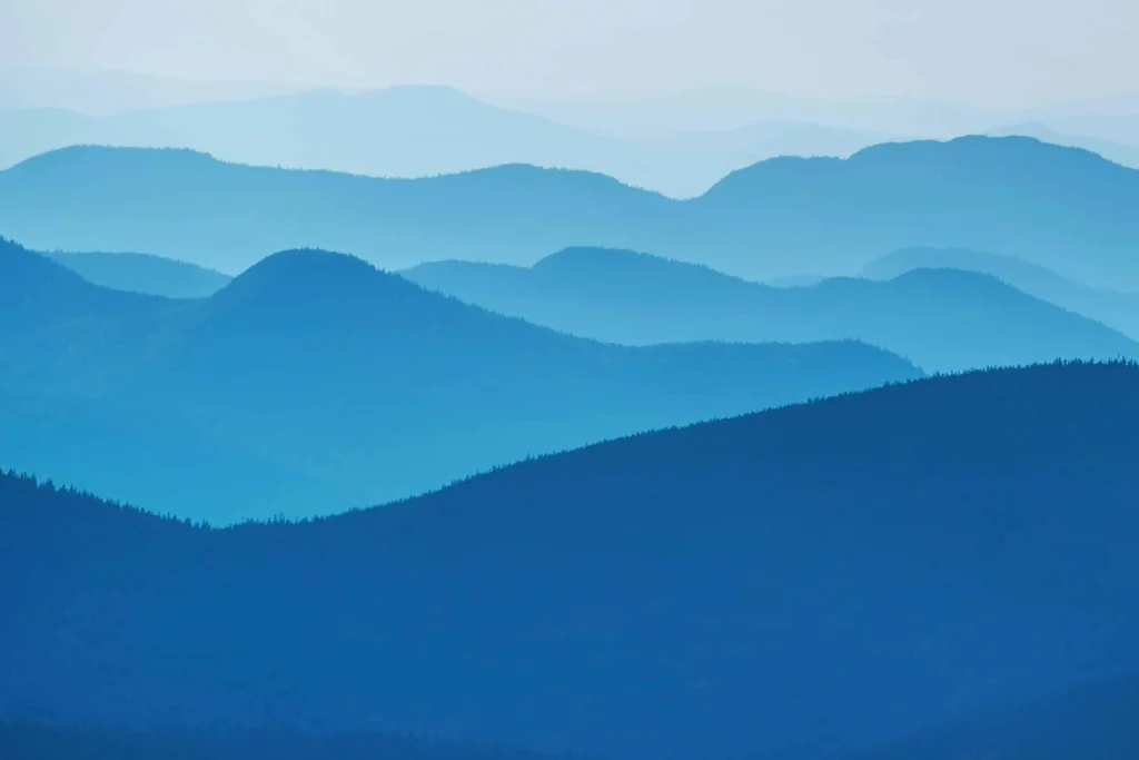  Blue-hued layers of the Adirondack Mountains under a misty morning sky.