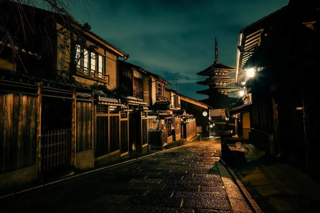 Traditional Japanese houses lining a quiet street in Kyoto at night to include in your japan itinerary 14 days