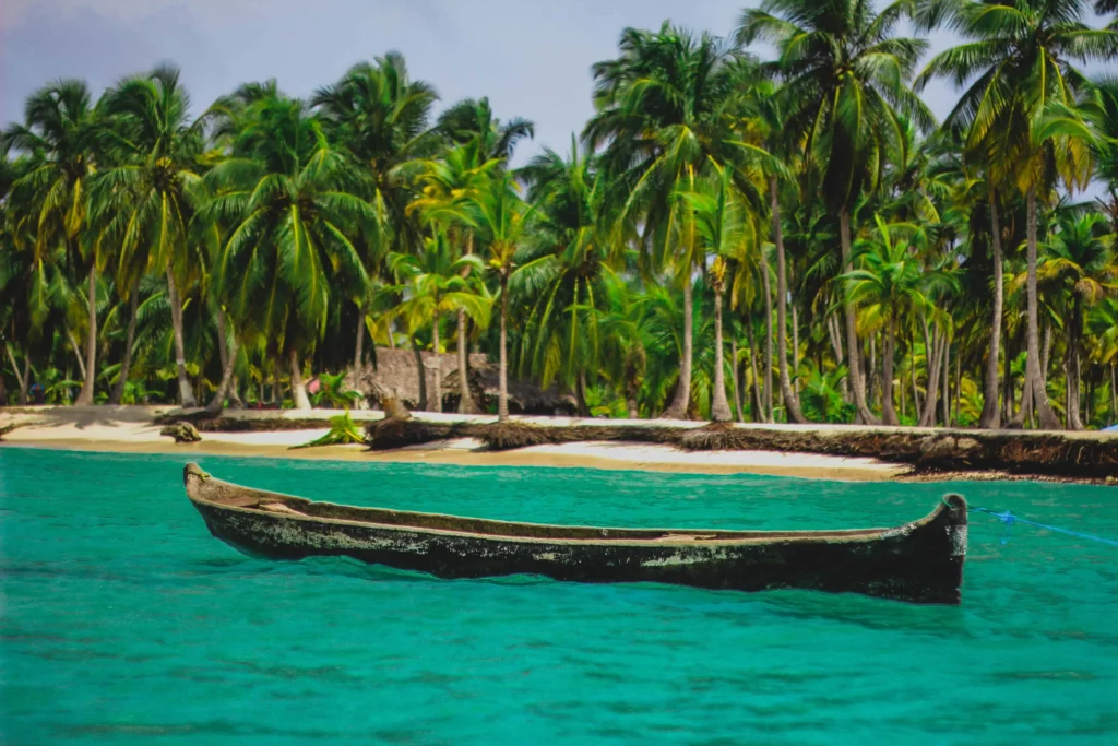 A secluded beach with turquoise waters and lush palm trees in the San Blas Islands, Panama.