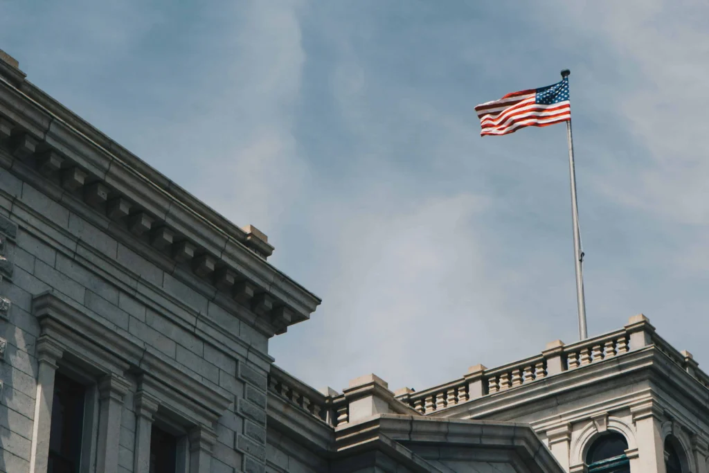 An American flag waving atop a historic building with neoclassical architecture in Charleston, SC.