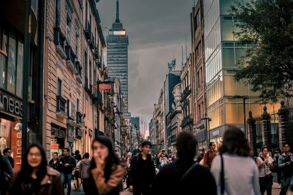 Vibrant streets of Mexico City with people walking and the Torre Latinoamericana in the background, showcasing one of the safest cities in Mexico.