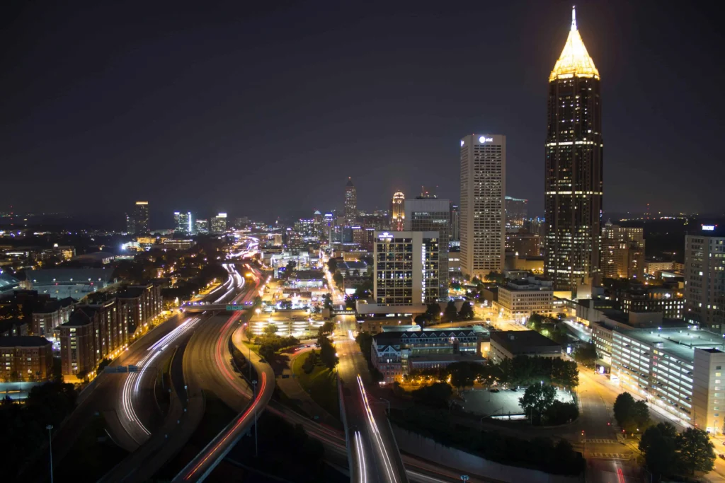 Midtown Atlanta’s skyline at night with lit-up buildings and busy roads