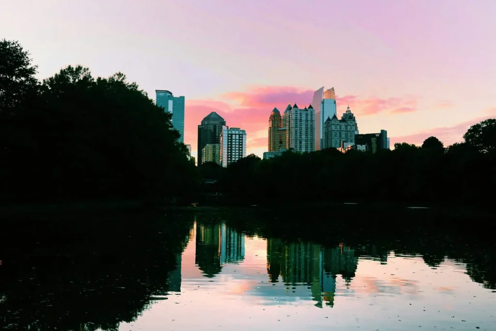 Piedmont Park in Atlanta with a reflection of the city’s skyline during sunset.
