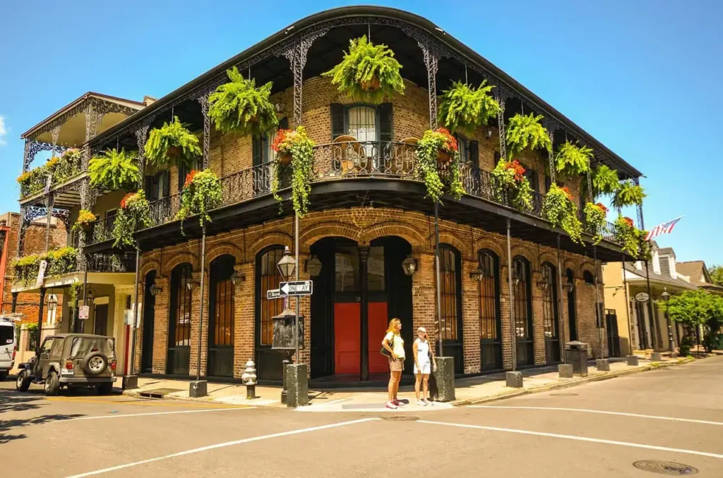 A vibrant building in New Orleans’ French Quarter with iron balconies and greenery with boutique hotels new orleans nearby