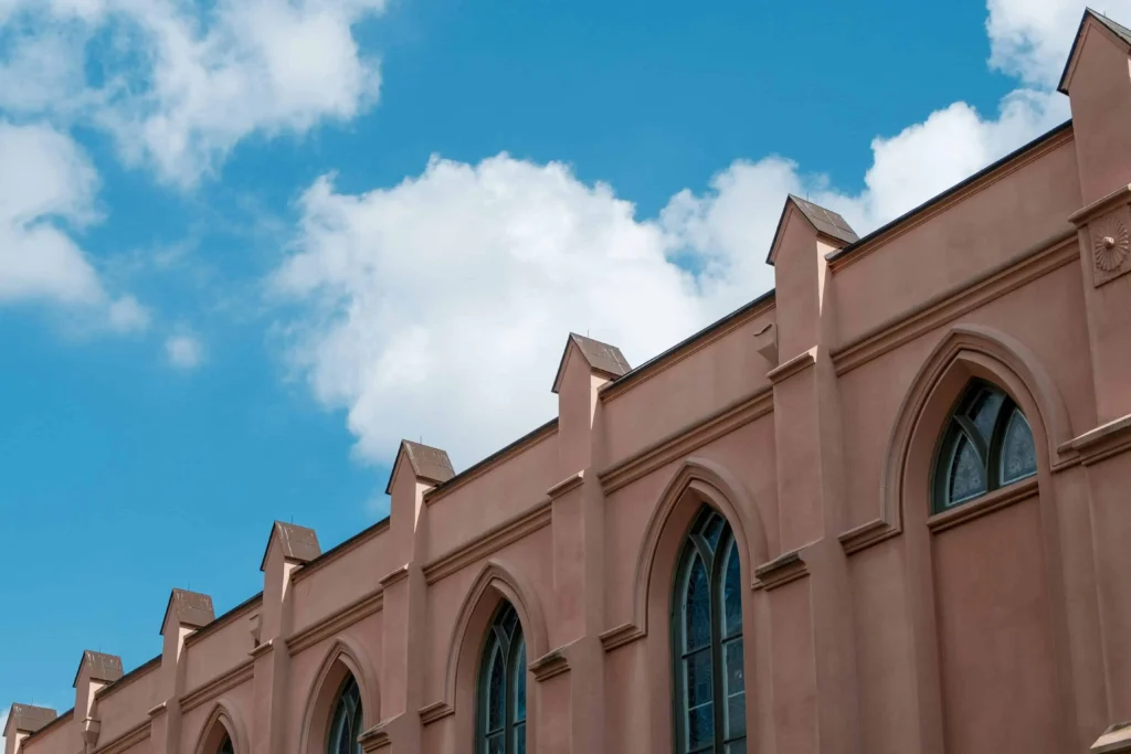 The facade of St. Louis Cathedral in New Orleans against a bright blue sky.