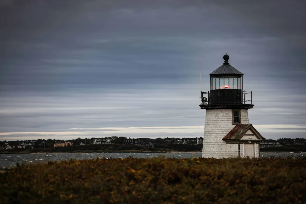 The Great Point Lighthouse in Nantucket with a moody, cloudy sky.