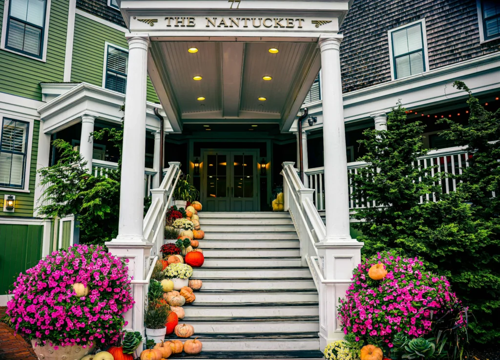 Front entrance of The Nantucket Hotel decorated with seasonal flowers and pumpkins.