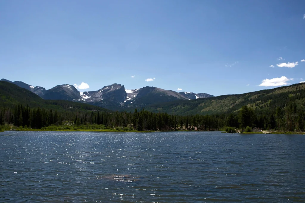 A stunning lake reflecting the mountains near Cody, Wyoming, offering a peaceful escape.