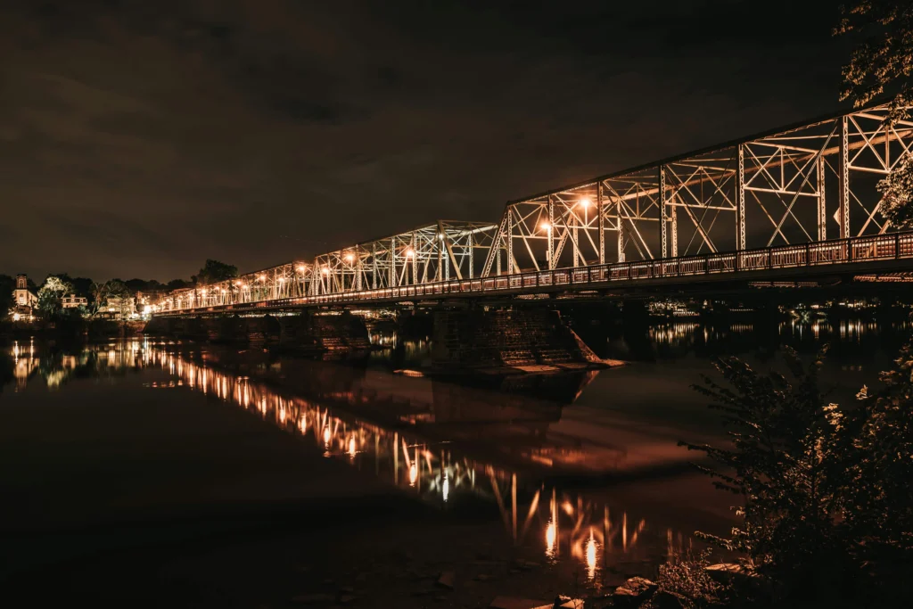 Illuminated steel bridge at night over the Delaware River in New Hope, PA.