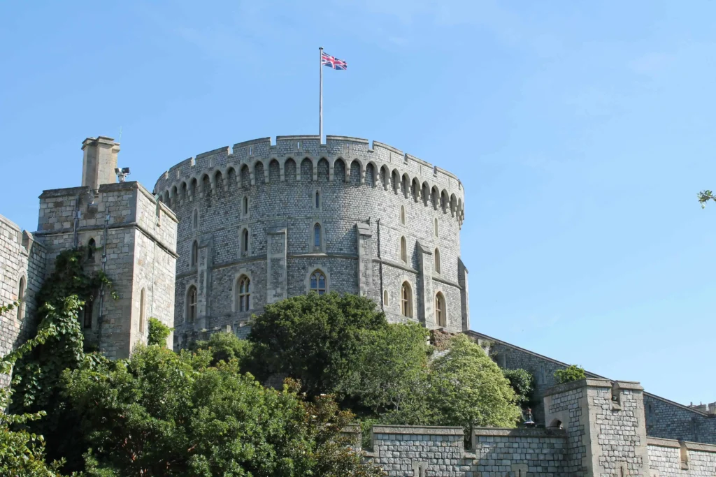 The iconic Round Tower of Windsor Castle on a bright, sunny day with a Union Jack flying high.