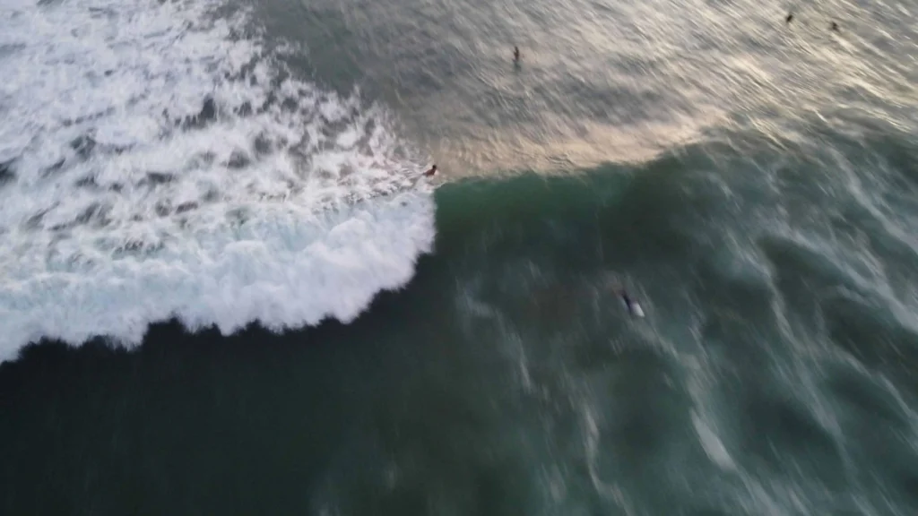 A surfer catching a wave in the blue waters off Tamarindo Beach, Costa Rica.