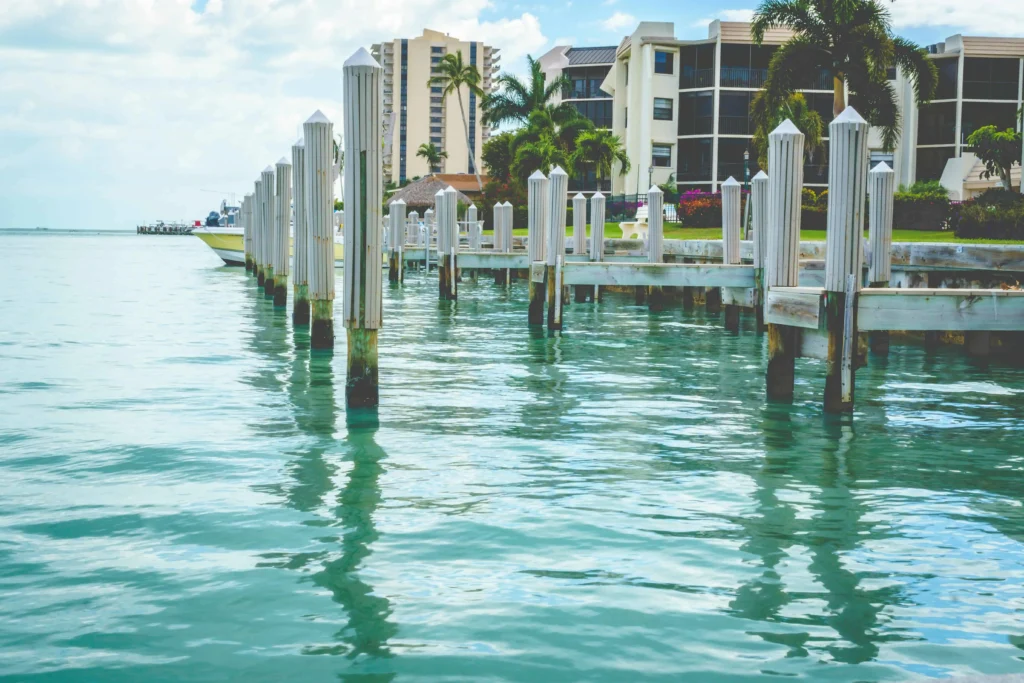 A serene waterfront view with docks and tropical buildings in Marco Island, Florida.