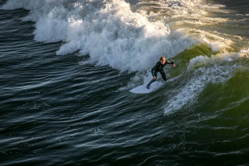 A surfer catching a wave during golden hour at Pismo Beach.