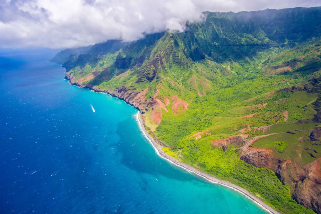 Aerial view of Kauai’s coastline with blue waters and lush landscapes.