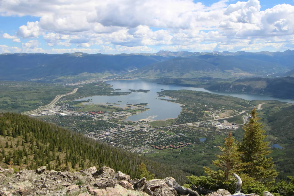 an aerial view of the town, its lake, and surrounding green mountains